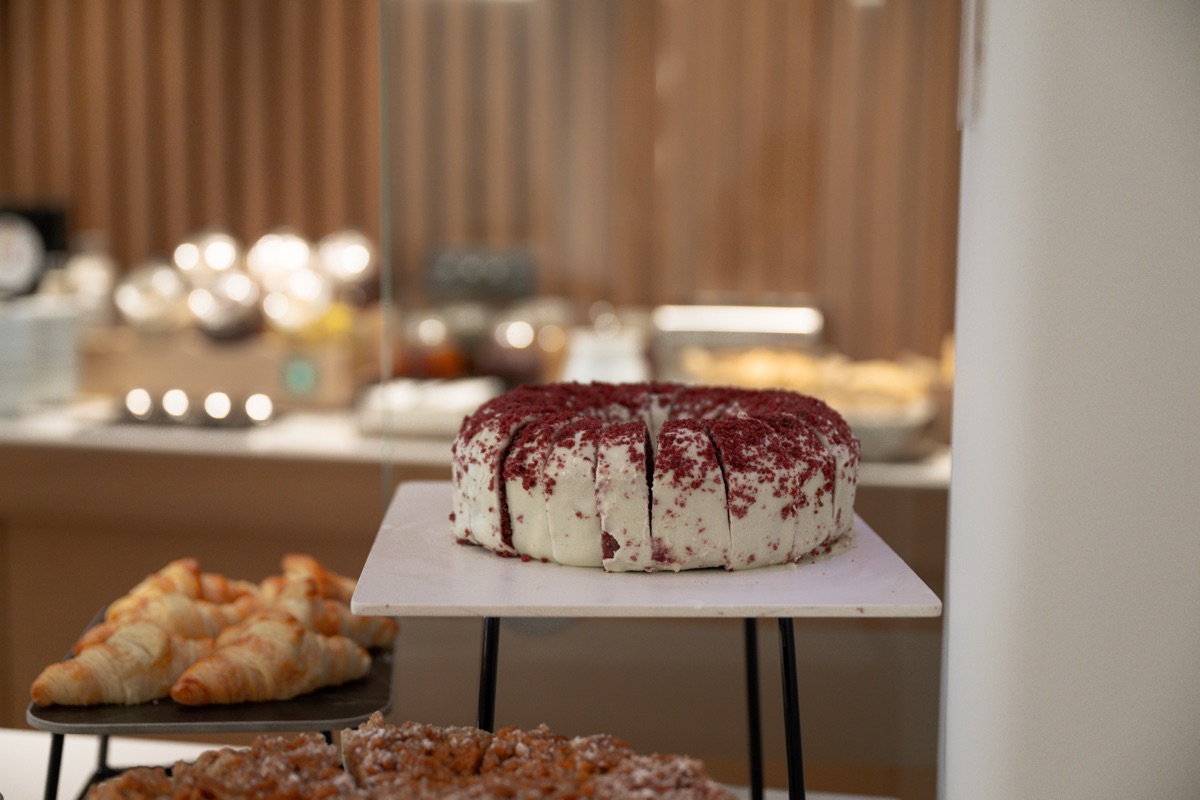 A dessert table, with red velvet cake and pastries
